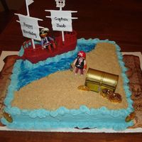 Pirate Cake This was made using a square cake pan. The sand is crushed vanilla wafers and the water is blue buttercream swirled with blue gel.