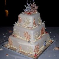 Seashell WASC cake with orange filling and vanilla buttercream. Covered in fondant. Shells are gumpaste colored with luster dust. The coral is white...