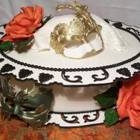 Day Of Sharing Demo Cake Masks and roses are gumpaste. Cake is covered in fondant. The top and bottom pieces are made separately to dry. Cutouts and edges are...