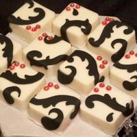 Wedding Shower Petit Fors WASC cake with buttercream and raspberry filling covered in white chocolate. Decorated with fondants scrolls and silver dragees