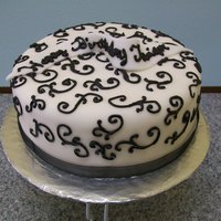 Scroll Triple Chocolate cake with chocolate ganache filling covered in MMF. Chocolate scroll work.