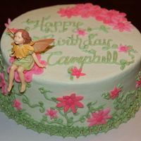 Fairy-Licious! A precious little fairy ornament sets off this simple birthday cake design. Buttercream frosting w/ fondant accents and silver dragees.