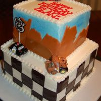 Disney Cars Birthday A two-tiered Cars themed birthday cake. Fondant accents. Toy cars.