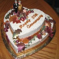 50Th Anniversary Cake This cake is a white cake with Cinnamon Buttercream frosting. The leaves and bands around the bottom of the cake are made of fondant and...