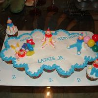 Clown Cupcake Cake Made for my nephew's 2nd birthday. Yellow cupcake with buttercream icing. Clowns made from icing. Balloons/Clown heads were brought.