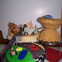 Cars on 3 tier cake stand/ royal icing buidings, rice krispi mountain. road from mountain is peanut butter (dirt) with cookie crumbs on cake...