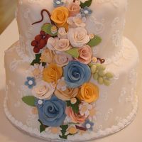Floral Cascade A cascade of handmade gumpaste roses, grapes, and daisies flowing from within a fondant-covered cake. Fondant was covered in inctricate...