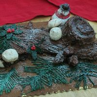 Buche De Noel (Snowflakes) This is it after the confectionary sugar snowstorm. The snowman and mushrooms are meringue. The pine boughs and holly are chocolate melts,...