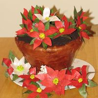 Poinsettia Flower Pot Cake Chocolate Cake with Buttercream covered with fondant. The flowers are gumpaste.