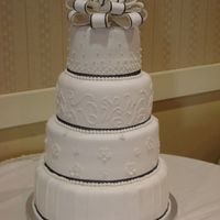 Laura's Wedding Fondant covered with fondant accents... real ribbon around base of each tier and 1/8 inch ribbon around edges of fondant bow.