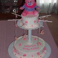 Pink Baby Mobile Pink baby mobile. 12 inch round and 6 inch round cakes. All buttercream icing with fondant baby accents.