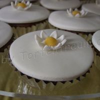 Marguerite Cupcake Cupcake covered in sugarpaste. The marguerite are sugarpaste/flowerpaste mix.