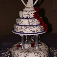 4 Teir Round Wedding Cake. covered in white buttercream icing. Rolled fondant with Wilton impressions mat covered all cakes outlined swirls with Wilton "...