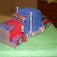 Optimus Prime carved cake to form truck, molded and hand painted with (petal dust) fondant accessories and truck