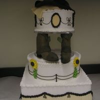 Western Wedding Cake This is acually a dummie cake I made at school. The layers are covered in RI with fondant fringe and fence work. The Pillars are inside...