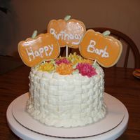 Fall Birthday Vanilla cake frosted with whipped vanilla buttercream. The mums are stiff buttercream, and the pumpkins are sugar cookies.