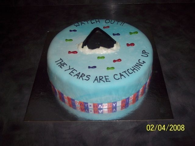 Shark Attack Birthday cake for a 60th birthday at work. The guy the cake was for loves fishing...Caramel mud cake with fondant icing and shark fin. Fish...