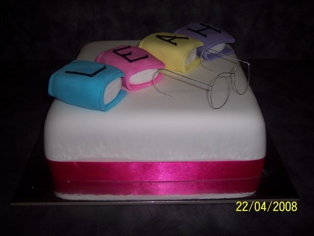 Books And Glasses 9 Inch square white choc mud cake with fondant icing. Books are fondant piped with royal icing and glasses are made from wire.