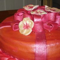 Orange W/ Pink Ribbon fudge round cake covered w/ orange mmf w/ mmf ribbon, all painted with orchid pink pearl luster.