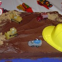 Construction Cake BC frosting. Brown sugar for sand. Construction vehicles candles and a small plastic hardhat for decorations.