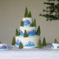 My Brothers Cake Marshmallow fondant covered cake with buttercream painting on the sides and royal trees with pine cones. Rocks made with MMF also.