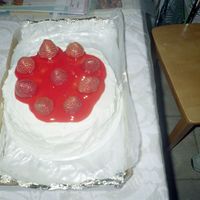 Strawberry Shortcake Two layer cake with whipped icing in between the layers and also on top and around with fresh strawberries on top.