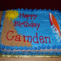 Surfer Cake Icing was buttercream. Surf board is colorflow. Sand is graham cracker crumbs.