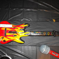 Guitar Hero Guitar Cake Cake was made using an acutal guitar hero guitar as a pattern. Neck of guitar is rice krispie treats and big part of guitar is chocolate...