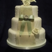 Vintage Green Wedding Cake With Bow Fondant covered cake with brush embroidery, quilting and piped dots. Gumpaste bow and flowers and dragee brooch.