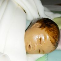 One Of The Twin's Faces This was the boy (Cameron). I added a bow to the girl's head (Cloe). Both were formed from fondant and gum tex.