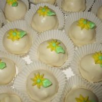 Cake Balls/truffles Lemon cake and lemon icing inside. Covered in white chocolate. Buttercream accents on top.