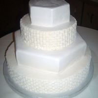Simple Wedding Cake Fluffy white cake with pure white buttercream. Basketweave buttercream and white chocolate fondant adorne alternating tiers.
