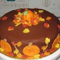 Fall Cake Color flow pumpkins with leaves and fondant pumpkin on top.