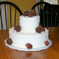 Sweetheart Cake frosted in buttercream topped with chocolate covered strawberries.