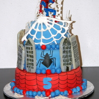 Spiderman A tiered Spiderman City cake inspired by CC artist shelleylynn -- Tiers covered with MMF, buildings are glazed sugar cookies. Black details...