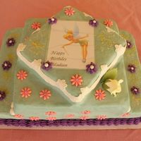 Tinkerbell Cake is decorated in various colors of buttercream with fondant accents and a laminated bookmark to remember the occasion.