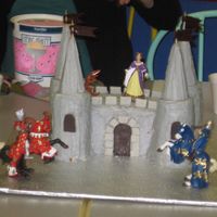 A Knight's Castle My nephew is into knights and dragons. He wanted a castle cake. It's all cake with bc and chocolate accents. The flags on the turrets...