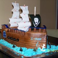 Pirate Ship All white cake covered in buttercream and airbrushed. Tootsie Rolls and Rolos for cannons. Gumpaste for sails and sharks, fondant for...