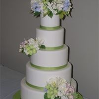 Spring Flowers Wedding Cake Stacked 5 tiers cake covered with fondant and grosgrain ribbonat bases. Gumpaste flower bouquets including tulips, gardenias, hydrangea,...