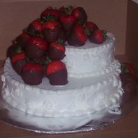 Strawbery Delight two tiered caked off set and decorated in vanilla buttercream and chocolate hand-dipped strawberrries