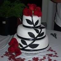 Classy Cake top and bottom layer is white cake and middle is red velvet.. all has butter cream icing and fondant. Black fondant leaves and stem . black...