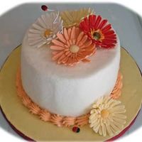 Shannon's Daisies Gumpaste daisies ( a couple have fondant/gumpaste combo) on yellow with buttercream cake.