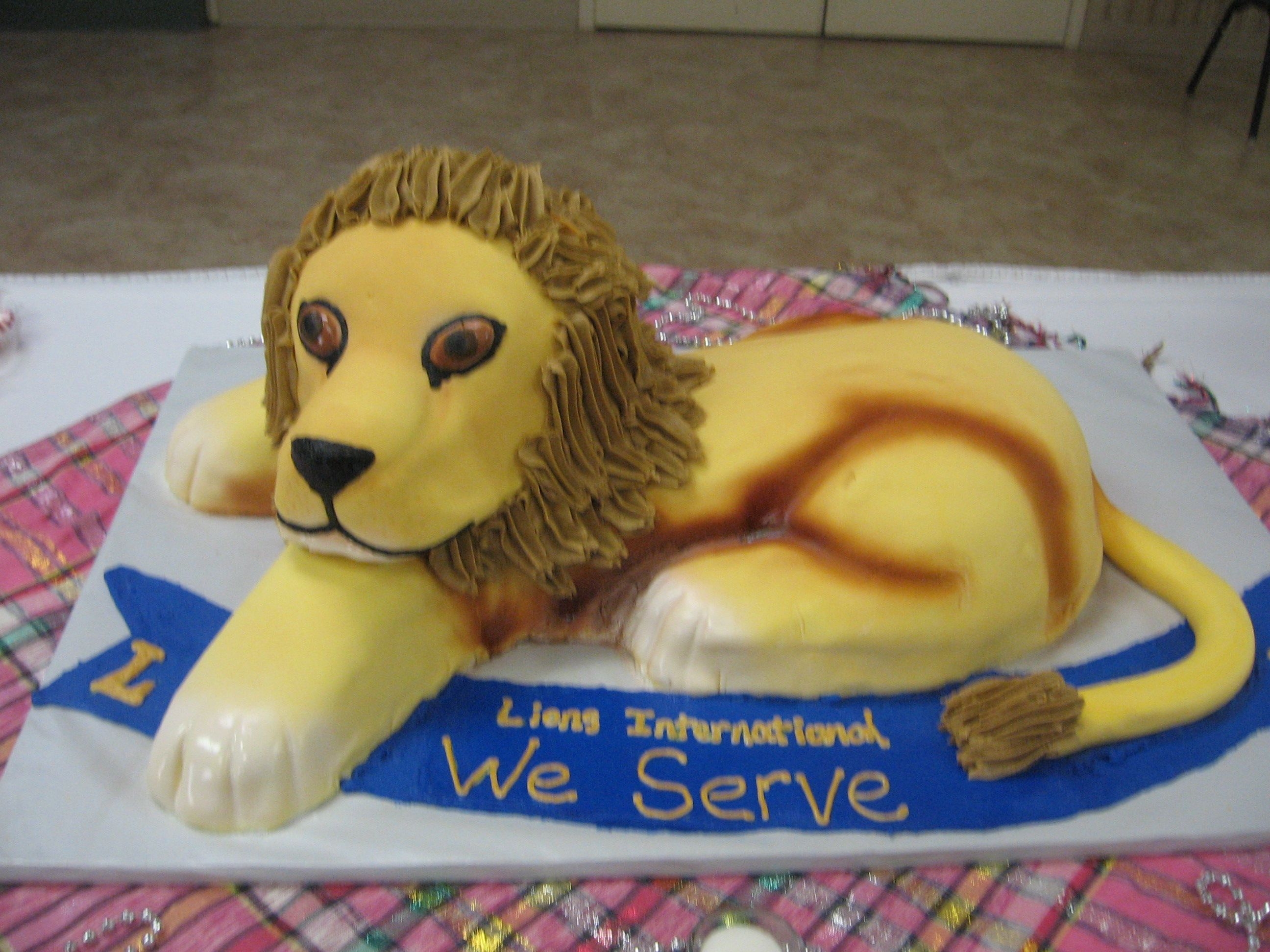 Lion Cake made for a Lion's Club meeting. The body is two half sheets cut and covered in fondant. The head is 3 round cakes stacked with a...