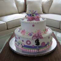 Mod Mom Girl Buttercream frosting with royal icing flowers. Fondant bow and booties.