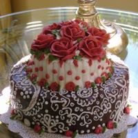 Piped Cake With Red Roses the cake is done in buttercream with piping on the base cake. the roses are built on kisses :-) thanks for looking!