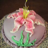 Sarah's Birthday Cake We have a staff member who loves the color purple and stargazer lilies. The covering is a combination Rolled Butter Cream and Fondant. The...