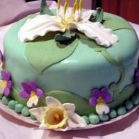 Trillium Cake Trillium, daffodils and violets are made out of modeling chocolate. Background is rolled buttercream.