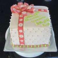 Pink Box Shaped Ribbon Cake 8" square pans. Pink strawberry flavored b.c. icing. Non eddible ribbon. The writing says "God's gift to the world...a...