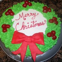 Christmas Wreath Cake for our family's Christmas dinner. Buttercream with cherries and fondant bow, first time working with fondant.