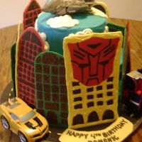 Transformers Thanks for all the ideas on here! Chocolate cake with chocchip buttercream. The buildings are made out of chocolate. Toys are real(4y/o...